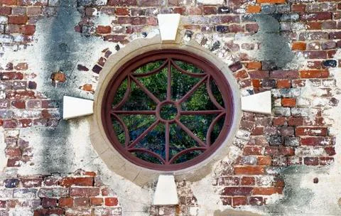 An old ornate circular window of iron work and brick from the eighteenth cent Stock-Fotos