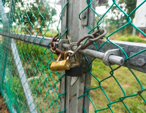Old padlock and rusty chain at fence Stock Photos