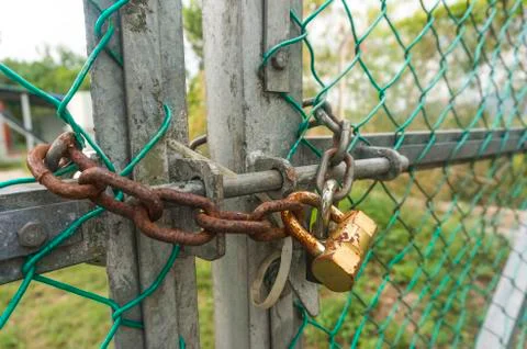 Old padlock and rusty chain at fence Stock Photos