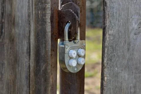 Old padlock code lock hanging on a wooden gate Stock Photos