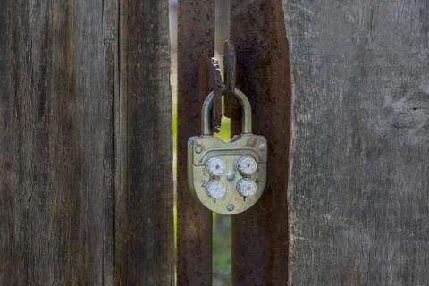 Old padlock code lock hanging on a wooden gate Stock Photos