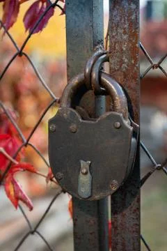 Old padlock on a rusty wire mesh gate Stock Photos