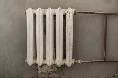 Old painted heating radiator. Pink dirty color. View from the front Stock Photos