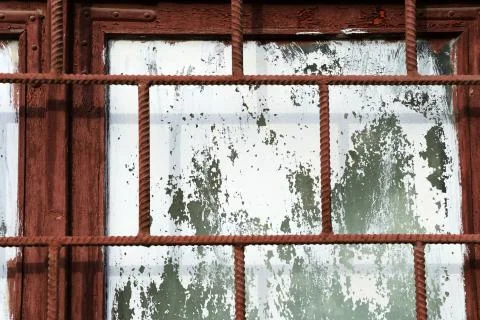Old painted window behind rusty grate close up Stock Photos