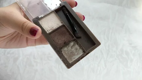 An old palette with eye shadow, face contouring in a womans hand.Makeup artist Vídeo Stock 314305542