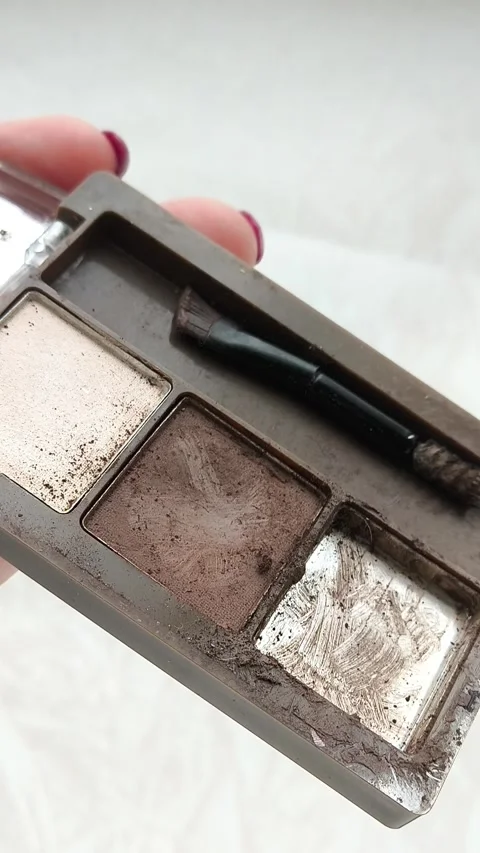 An old palette with eye shadow, face contouring in a womans hand.Makeup artist Video stock 314306567