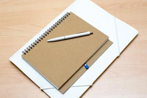 Old paper folder with white label closed on a white wooden background Stock Photos