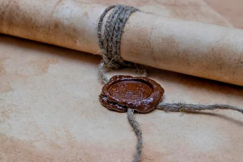 An old paper scroll sealed with a wax seal. The manuscript is rolled up and s Stock Photos