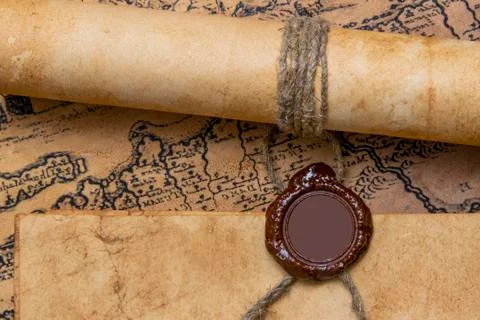 An old paper scroll sealed with a wax seal. The manuscript is rolled up and s Stock Photos