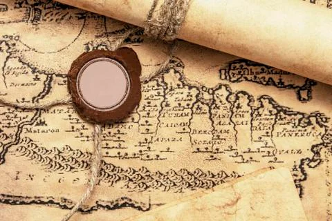 An old paper scroll sealed with a wax seal. The manuscript is rolled up and s Stock Photos