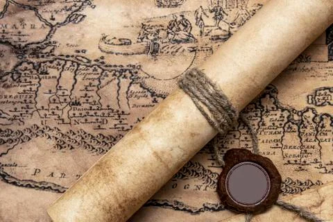 An old paper scroll sealed with a wax seal. The manuscript is rolled up and s Stock Photos