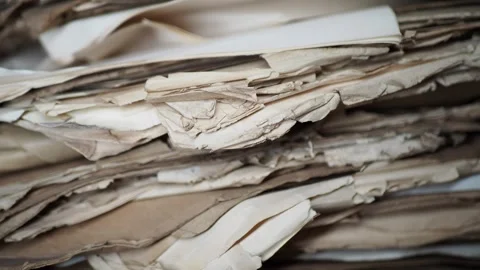Old papers stacked in a messy pile in an office setting Stock Footage 337445760