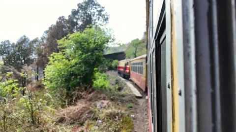 An old passenger train rounds a scenic bend in the mountains. Stock Footage 333902191