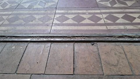Old patterned ceramic tiles meet worn wooden floor boards indoors Stock Photos