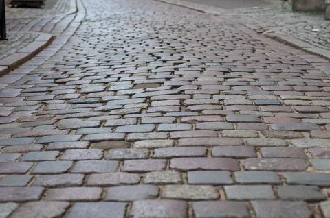 Old pavement lined with stone, stone pavement background close-up Stock Photos