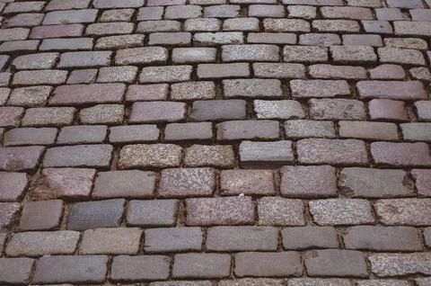 Old pavement lined with stone, stone pavement background close-up Stock Photos