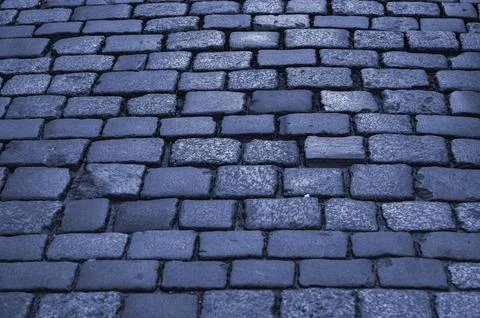 Old pavement. Pavement lined with stone, stone pavement background close-up. Stock Photos