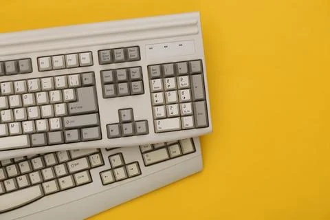 Old pc keyboards on yellow background. Top view. Flat lay Stock Photos