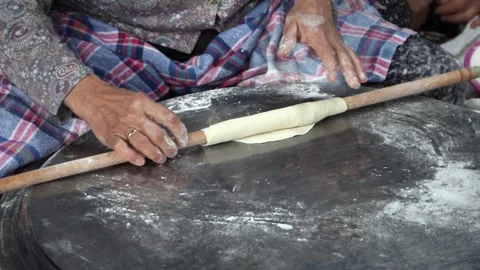 Old peasant woman preparing bread and pastries over a wood fire Stock Footage 292852275