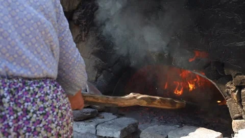 Old peasant woman preparing bread and pastries over a wood fire Stock Footage 292852313