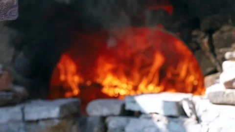 Old peasant woman preparing bread and pastries over a wood fire Stock Footage 292852348