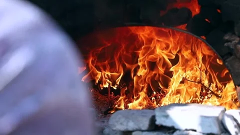 Old peasant woman preparing bread and pastries over a wood fire Stock Footage 292852355