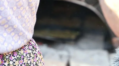 Old peasant woman preparing bread and pastries over a wood fire Stock Footage 292852412