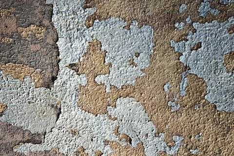 Old peeling paint on rough textured wall surface with cracked layers 스톡 사진