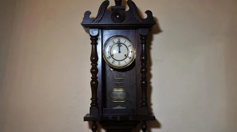 Old pendulum clock in front and in motion -  12 o'clock Stock Photos