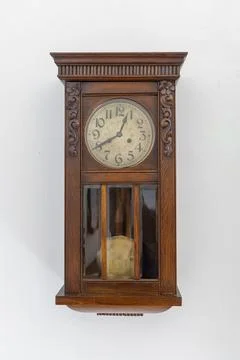 Old pendulum clock on a white wall. 스톡 사진