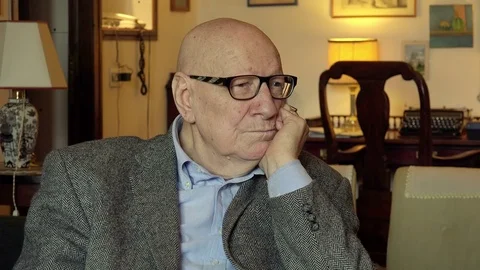 Old pensive man sitting alone in his livingroom at home: elegant elderly man Stock-Footage 74436427