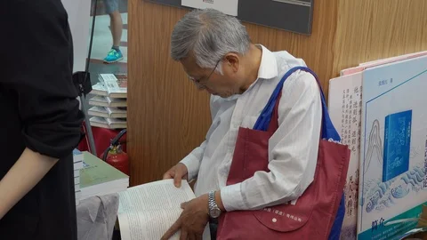 Old people focus on reading in 2019 Shanghai International Book Fair Stock Footage 124954733