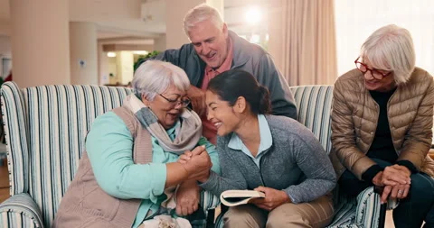 Old people, high five and nurse with book in nursing home, laughing and happy Stock Footage 341400902