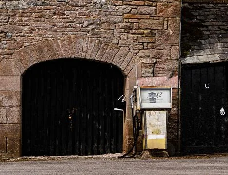 An old petrol pump by a barn Stock Photos