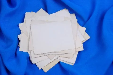 Old photos in a stack, on a creative blue background, frame for design. Stock Photos