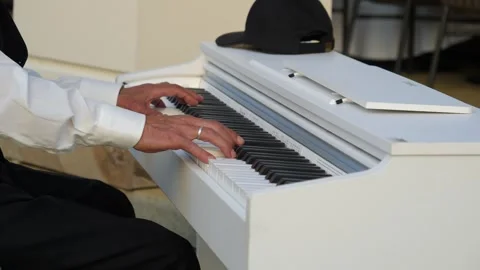 Old pianist creates magic with glissando on white piano. Video stock 274215766