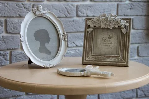 Old picture frames, lying mirror on the table with grey brick wall background Stock Photos