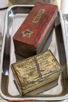 Old pill boxes on top of a silver tray from the last century Stock Photos