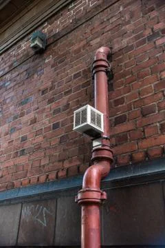 Old pipe brick wall valve vent painted rectangle Urban build texture modern u Stock Photos