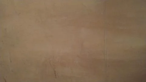 The old plaster wall with cracks and defects painted in brown. Background. Cl Stock Photos