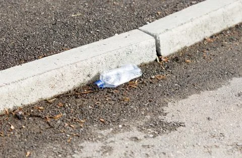 Old plastic bottle lying on the sidewalk Stock Photos
