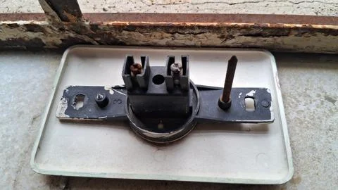 Old plastic electrical switch component with rusty metal mounting nails Stock Photos