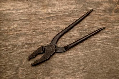 Old pliers on a wooden background Stock Photos