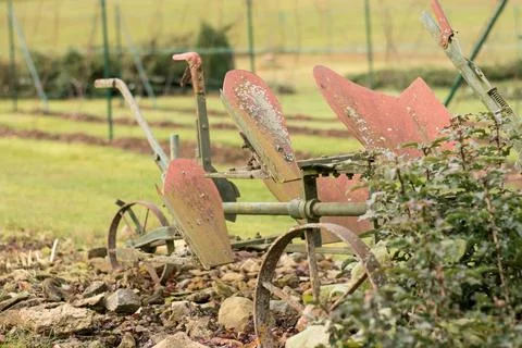 An old ploughing tool. Two-row rotary plough for ploughing. Background of a.. Stock Photos