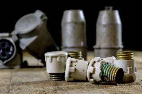 Old plug and socket high voltage. Old electrical accessories. Wooden table. Stock Photos