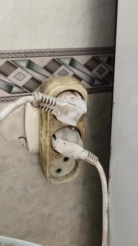 The old plugs are plugged into the socket with an adapter. dangerous connection Stock Footage 325288197