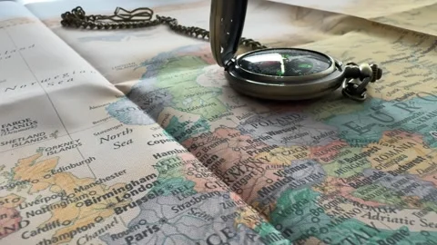 Old pocket compass resting on a folded map of Europe, representing travel Stock Footage 319518805