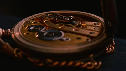 An old pocket watch with the back open, revealing gears and mechanism. Stock Footage 254541329