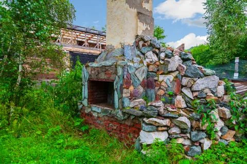 Old poor destroyed fireplace standing on the street with firewood inside, aft Foto stock