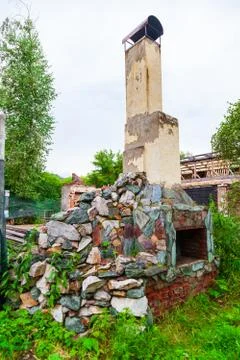 Old poor destroyed fireplace standing on the street with firewood inside, aft Stock Photos